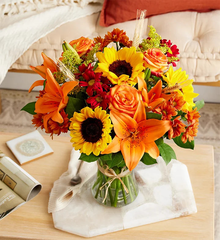 Bouquet of flowers with sunflowers and orange roses on a table.