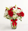 Fields of Europe Christmas Bouquet of red roses and white lilies with a red ribbon in a clear vase on a white background