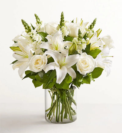 Classic All White Arrangement, Bouquet of white flowers in a clear vase on a white background Classic All White Arrangement, Bouquet of white flowers in a clear vase on a white background
