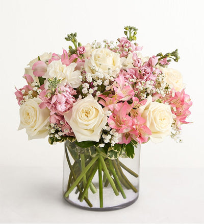 Bouquet of pink and white flowers in a clear vase on a white background Bouquet of pink and white flowers in a clear vase on a white background