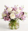 Lovely Lavender Medley for Winter Bouquet of white and purple flowers in a clear vase on a white background