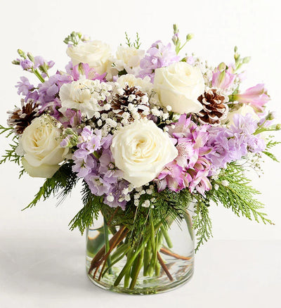 Lovely Lavender Medley for Winter Bouquet of white and purple flowers in a clear vase on a white background Lovely Lavender Medley for Winter Bouquet of white and purple flowers in a clear vase on a white background