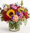Harvest Melody Bouquet Colorful bouquet of flowers in a clear vase on a white background