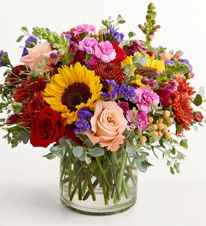 Harvest Melody Bouquet Colorful bouquet of flowers in a clear vase on a white background