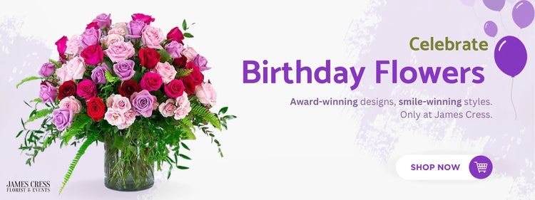 Assortment of roses in shades of pink, red, and purple arranged in a glass vase, with a promotional message for 'Birthday Flowers' by James Cress. Features a 'SHOP NOW' button and celebratory purple balloons.