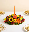 Fields of Europe for Fall Centerpiece, Colorful floral arrangement with a candle on a table setting.