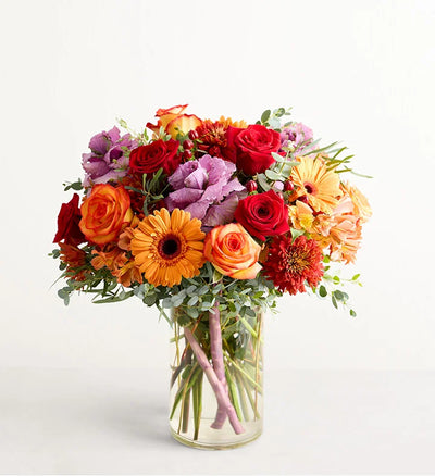 Garden of Grandeur for Fall Bouquet of colorful flowers in a clear vase on a light background Garden of Grandeur for Fall Bouquet of colorful flowers in a clear vase on a light background