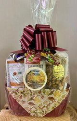 Gift basket with a large red bow, featuring various items including a bag of chips and a jar of preserves, on a neutral background.
