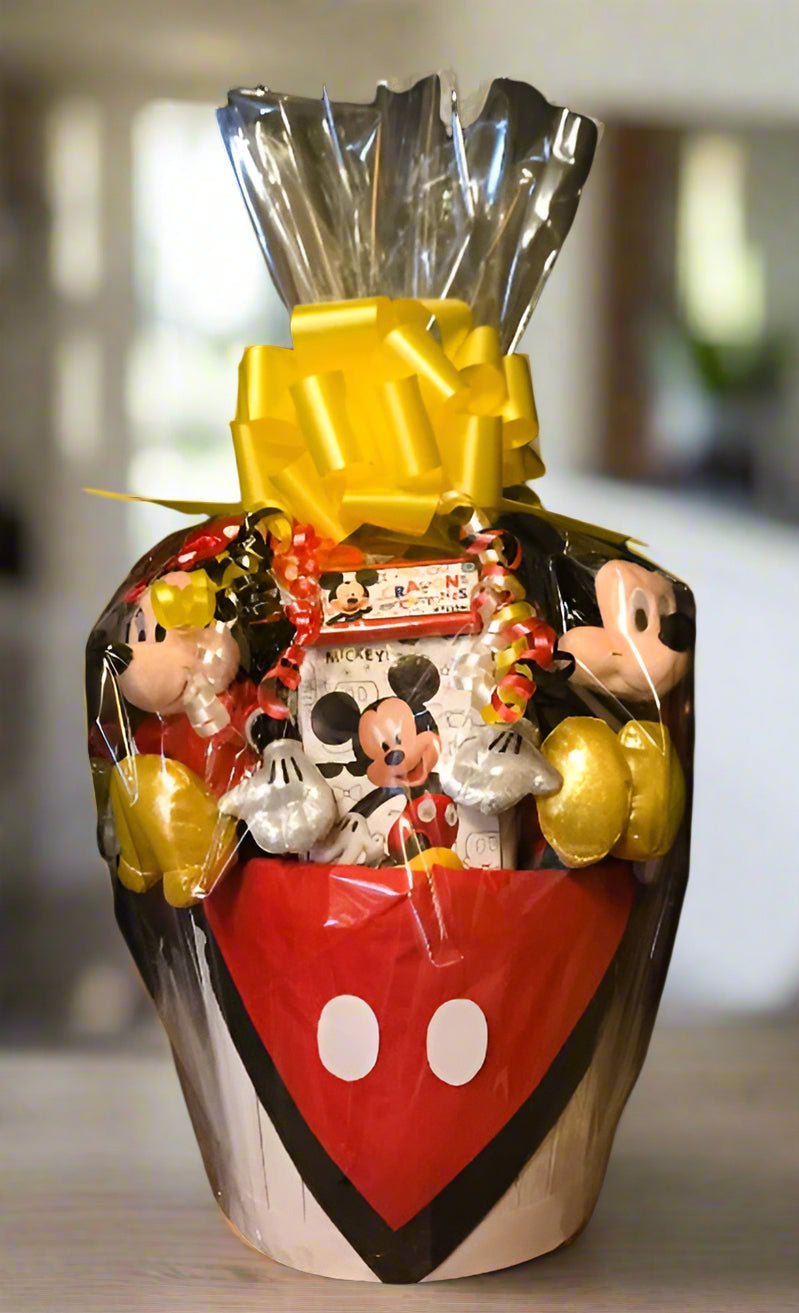 Gift Basket with Mickey Mouse-themed items including a heart-shaped container and wrapped candies on a black background.