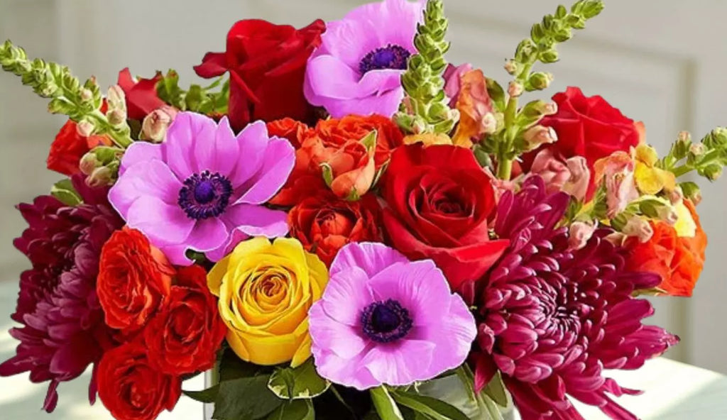 Colorful spring bouquet featuring roses, daisies, and tulips in a bright array, ideal for freshening up any room. View our collection of springtime blooms that brighten rooms. Shop now for vibrant spring flowers.