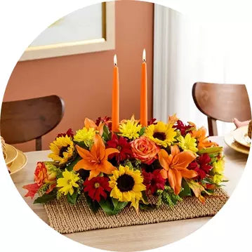 Decorative Thanksgiving floral arrangement with candles on a table setting.
