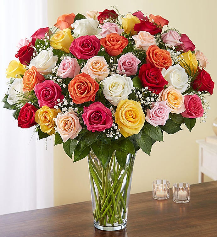 48 Stems Assorted Exquisite bouquet of multicolored long-stem roses arranged in a tall clear glass vase, featuring a vibrant mix of red, pink, yellow, and orange roses with baby’s breath and greenery, ideal for expressing grand emotions.