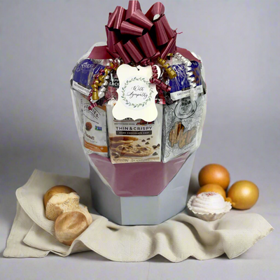 Gift basket with a variety of items including cookies and a card, on a gray background. Gift basket with a variety of items including cookies and a card, on a gray background.