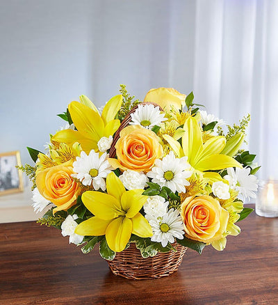 Medium yellow and white floral arrangement in wicker basket featuring yellow roses, Asiatic lilies, alstroemeria, white daisy poms, and mini carnations with lush greenery, perfect for conveying support and blessings. Medium yellow and white floral arrangement in wicker basket featuring yellow roses, Asiatic lilies, alstroemeria, white daisy poms, and mini carnations with lush greenery, perfect for conveying support and blessings.