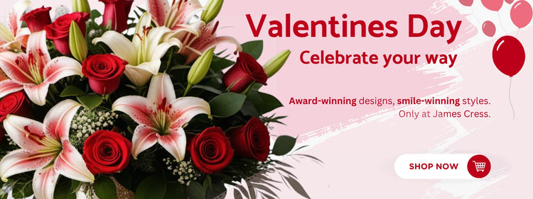 Valentine's Day flower arrangement featuring red roses and white lilies with pink accents, surrounded by green foliage. Pink background with red balloon graphics and a promotional message for James Cress Florist. A shop now button encourages purchases.