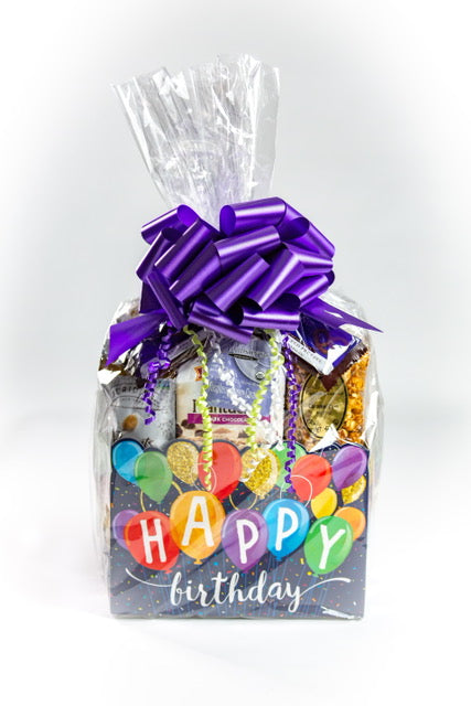 Gift basket with a purple bow labeled 'Happy Birthday' on a white background