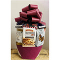Gift basket with a large red bow containing snacks and cookies on a neutral background